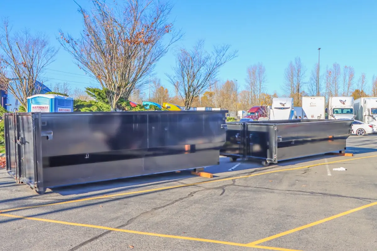 Professional dumpster rental service with roll-off container on residential driveway in Bondurant